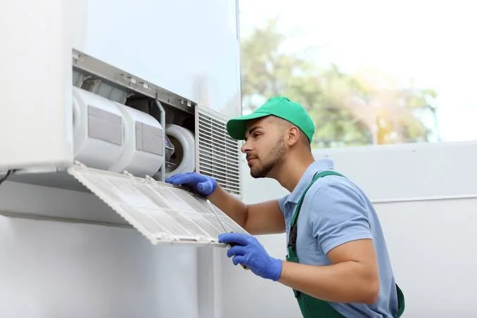 Technician inspecting a clean HVAC air filter inside residential equipment