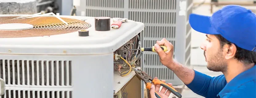 HVAC technician performing routine service on an outdoor condenser